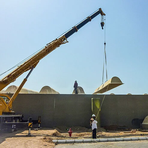 Kran hebt eine GFK-Abdecksystem-Komponente bei der Montage vor Ort an einer Kläranlage